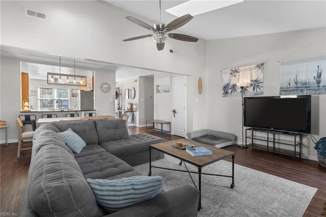 living room featuring ceiling fan, dark wood-type flooring, and vaulted ceiling