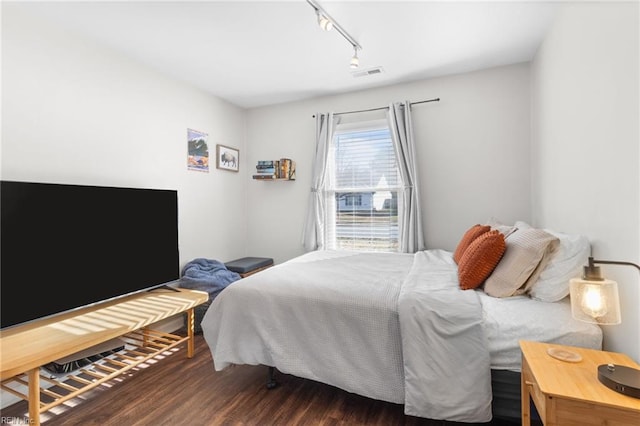 bedroom featuring dark wood-type flooring and track lighting