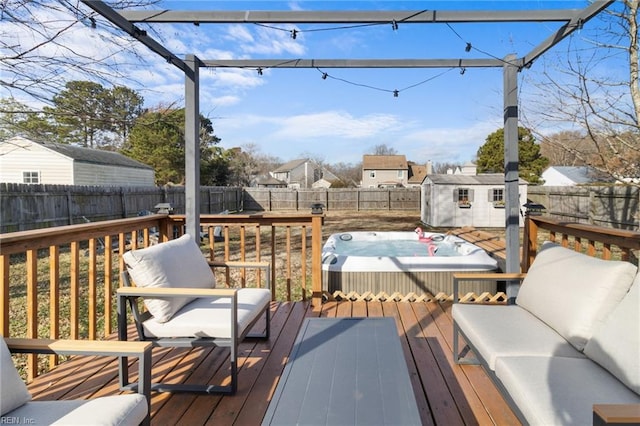 wooden terrace with a hot tub and a storage shed