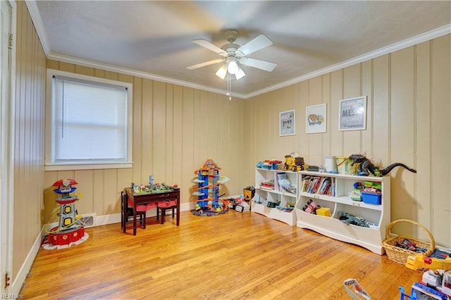 game room featuring hardwood / wood-style flooring, ceiling fan, and crown molding