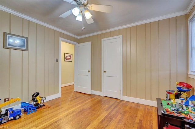 playroom featuring light hardwood / wood-style flooring, ceiling fan, and ornamental molding