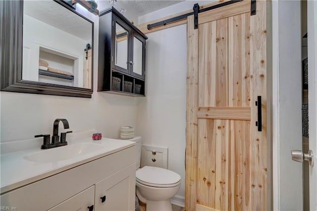 bathroom with vanity, toilet, and a textured ceiling