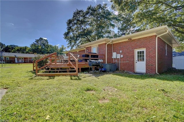 rear view of property with a lawn and a wooden deck