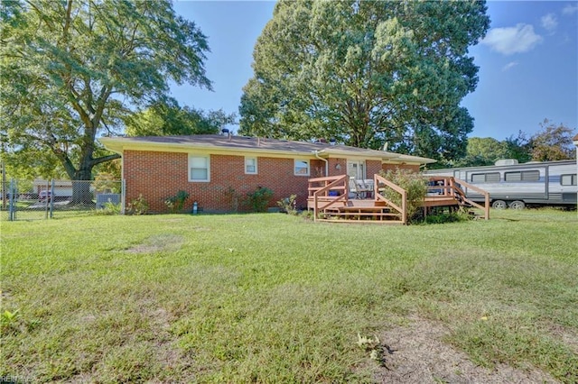 back of property featuring a lawn and a deck