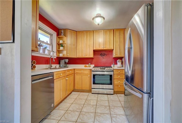 kitchen with sink, light tile patterned floors, light brown cabinets, and appliances with stainless steel finishes