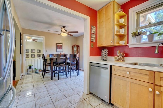 kitchen with ceiling fan, sink, light brown cabinets, light tile patterned flooring, and appliances with stainless steel finishes