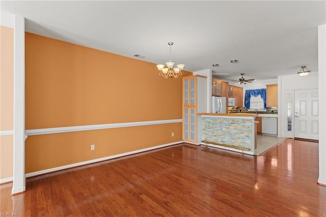 interior space with white appliances, ceiling fan with notable chandelier, sink, light hardwood / wood-style floors, and kitchen peninsula