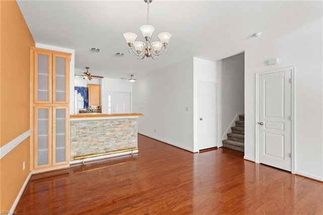 unfurnished living room with hardwood / wood-style flooring and ceiling fan with notable chandelier