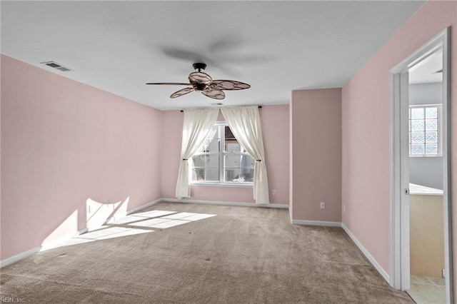 carpeted empty room featuring ceiling fan and a healthy amount of sunlight