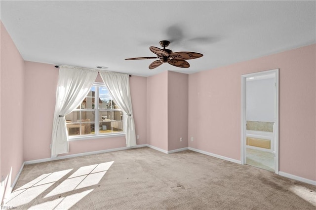 spare room featuring ceiling fan and light carpet