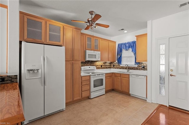 kitchen with backsplash, ceiling fan, sink, and white appliances