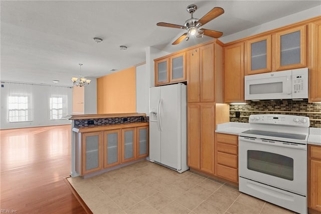 kitchen featuring tasteful backsplash, ceiling fan with notable chandelier, decorative light fixtures, and white appliances