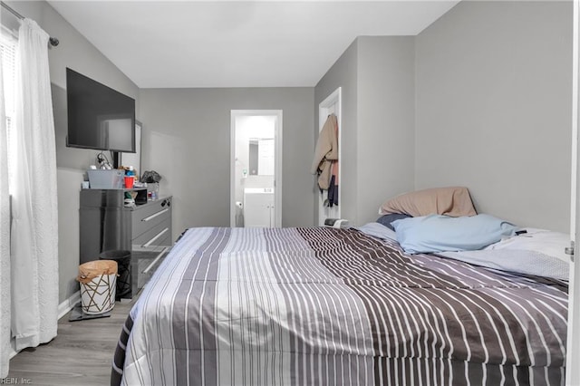 bedroom with light hardwood / wood-style flooring and ensuite bath