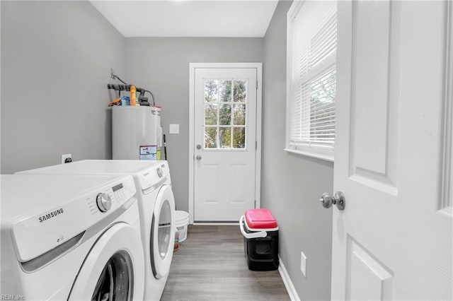 washroom featuring hardwood / wood-style floors, washer and dryer, and water heater