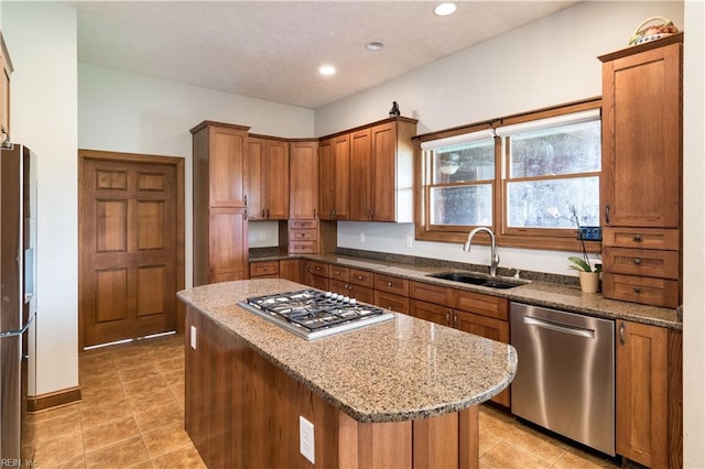 kitchen featuring a center island, stainless steel appliances, stone countertops, and sink