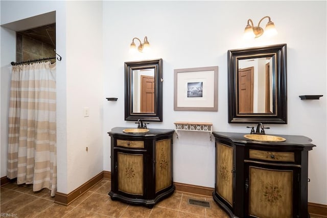 bathroom with tile patterned flooring, vanity, and walk in shower