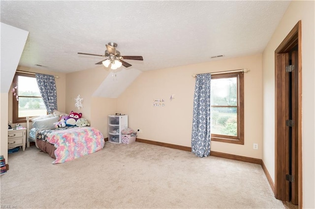 bedroom featuring multiple windows, light colored carpet, vaulted ceiling, and ceiling fan