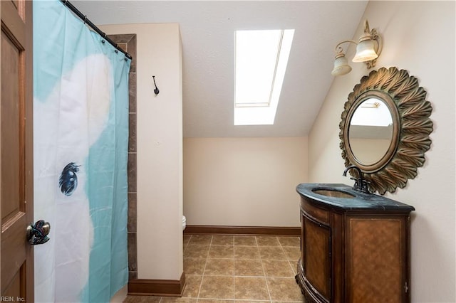 bathroom with vaulted ceiling with skylight, vanity, toilet, and walk in shower