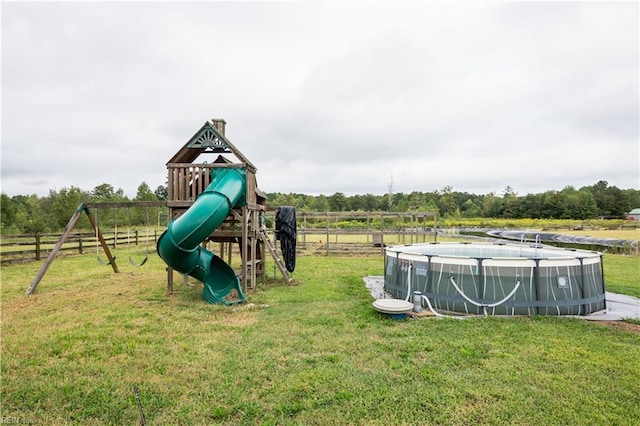 view of play area featuring a fenced in pool and a lawn