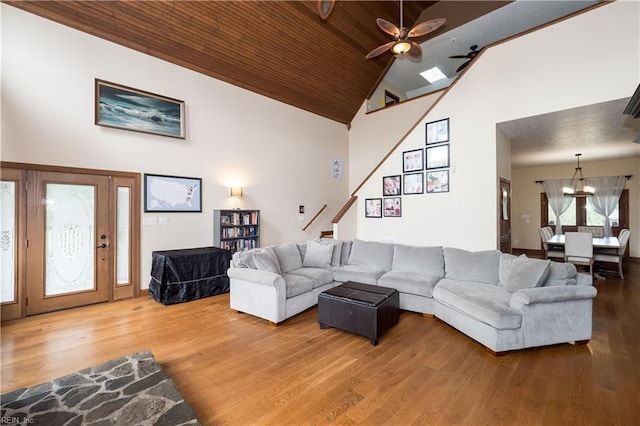 living room with ceiling fan, wood-type flooring, wood ceiling, and high vaulted ceiling