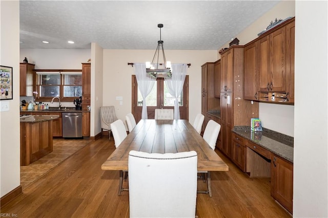 dining space with sink, dark hardwood / wood-style flooring, and a textured ceiling