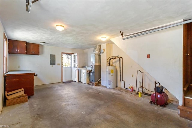 garage with heating unit, water heater, electric panel, and washing machine and clothes dryer