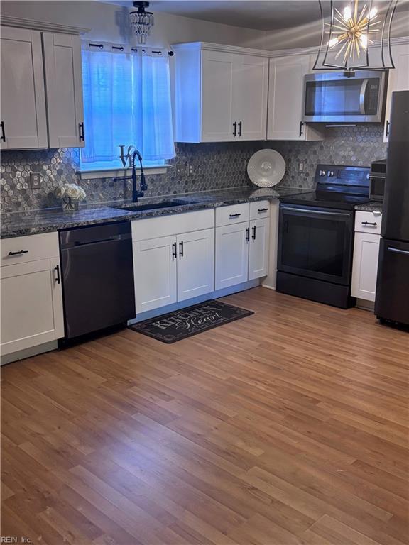 kitchen featuring white cabinets, dishwasher, refrigerator, and range with electric cooktop