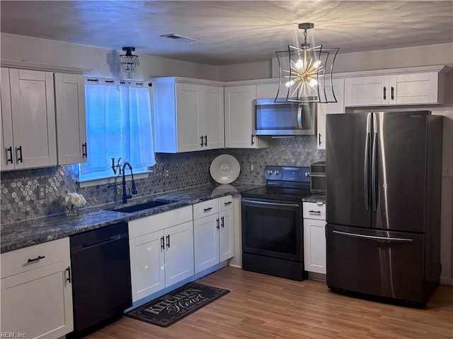 kitchen with white cabinets, pendant lighting, sink, and appliances with stainless steel finishes