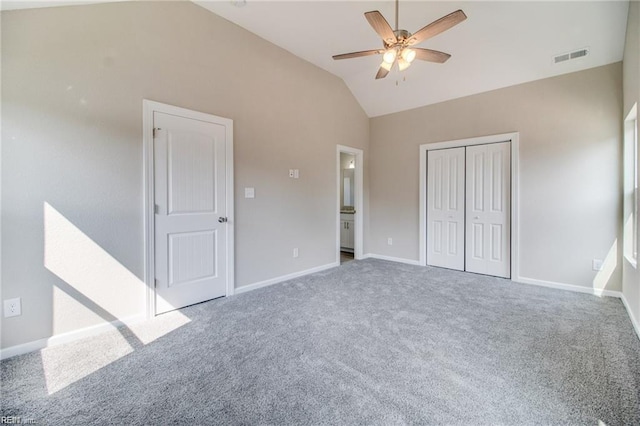 unfurnished bedroom with carpet flooring, a closet, vaulted ceiling, and ceiling fan