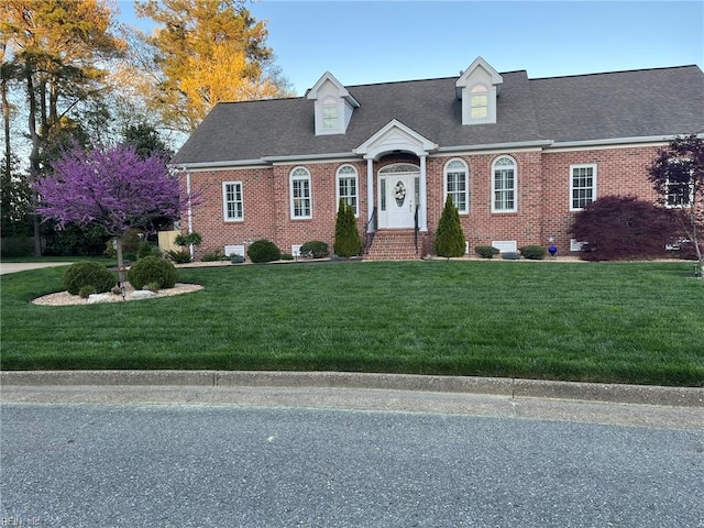 cape cod home featuring a front yard