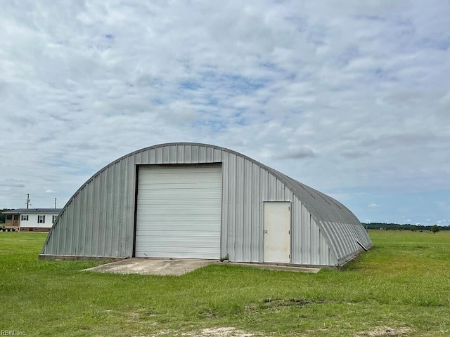 view of outdoor structure with a lawn and a garage