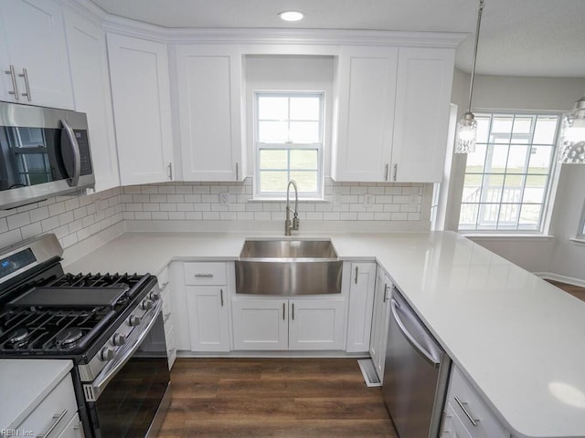 kitchen with backsplash, white cabinetry, sink, and appliances with stainless steel finishes