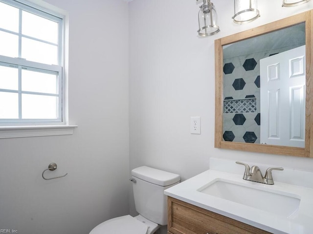 bathroom featuring vanity, toilet, and a healthy amount of sunlight