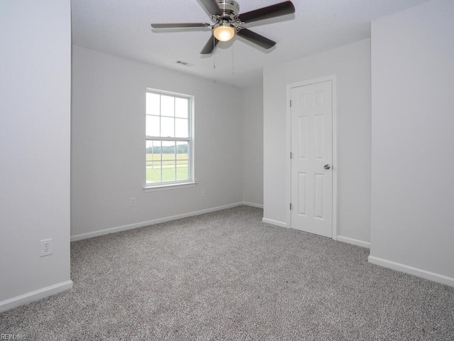 carpeted spare room featuring ceiling fan