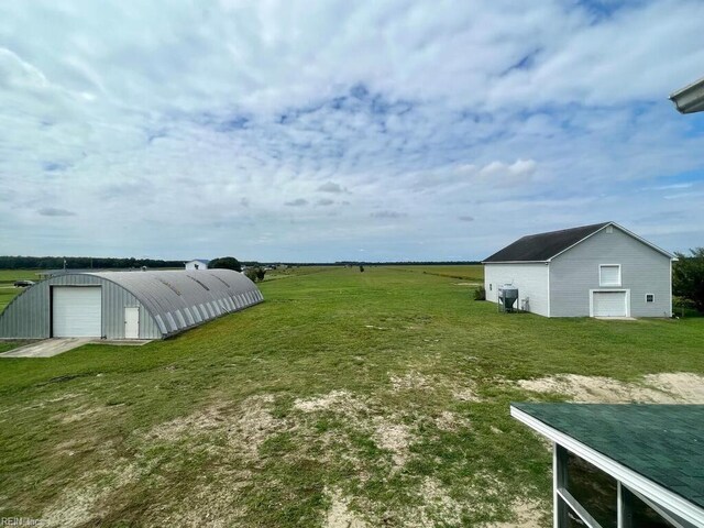 view of yard with a rural view and an outdoor structure