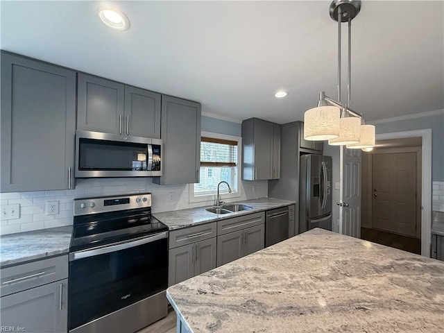 kitchen with light stone countertops, sink, pendant lighting, decorative backsplash, and appliances with stainless steel finishes