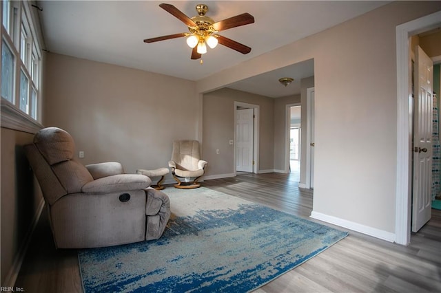 sitting room featuring wood-type flooring and ceiling fan