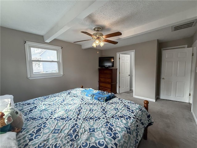 bedroom featuring carpet flooring, beam ceiling, a textured ceiling, and ceiling fan