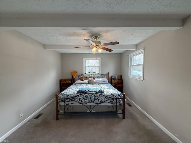 carpeted bedroom with beam ceiling, a textured ceiling, and ceiling fan