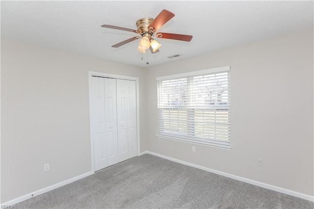 unfurnished bedroom with carpet, a closet, and ceiling fan