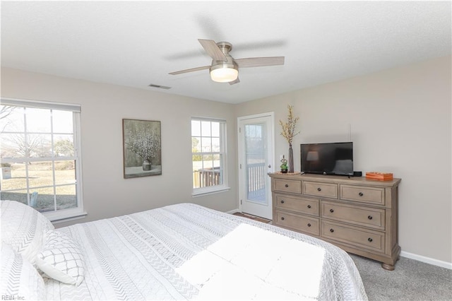 carpeted bedroom with ceiling fan, access to exterior, and multiple windows