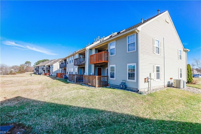 exterior space with a balcony, a yard, and central AC