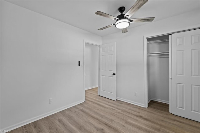 unfurnished bedroom featuring ceiling fan, a closet, and light hardwood / wood-style flooring