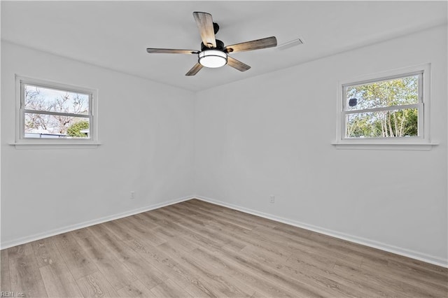 empty room with ceiling fan and light hardwood / wood-style floors