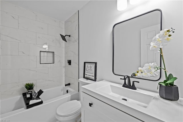 full bathroom featuring tiled shower / bath combo, toilet, and vanity