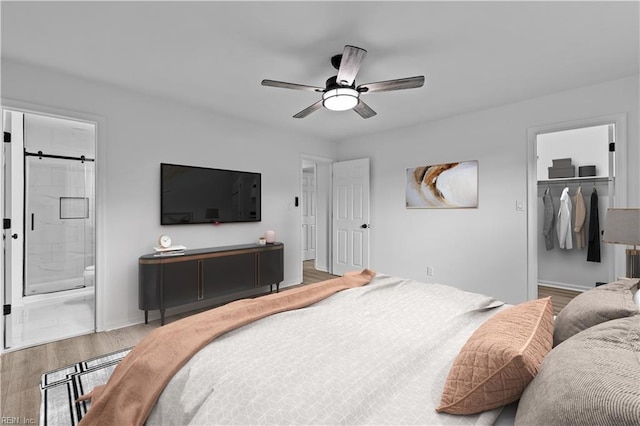 bedroom with ceiling fan, a spacious closet, ensuite bathroom, hardwood / wood-style floors, and a closet