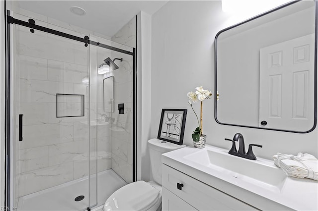 bathroom with vanity, toilet, and a shower with door