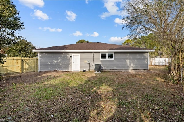 back of house with a lawn and central AC