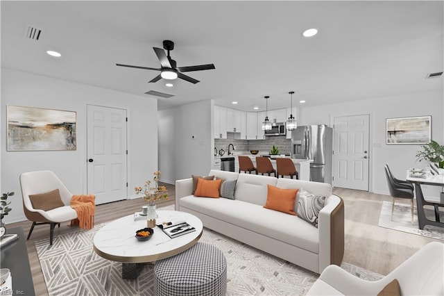 living room featuring ceiling fan and light hardwood / wood-style flooring