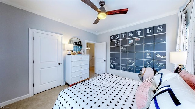 carpeted bedroom with ornamental molding and ceiling fan